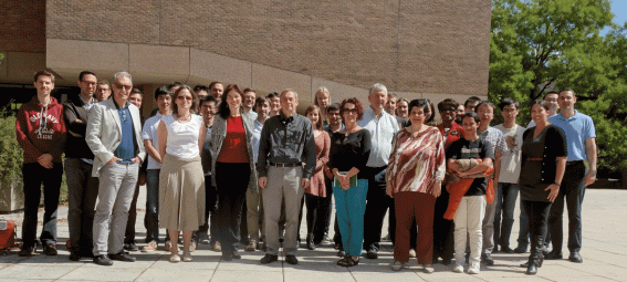 group of 30 people standing outside in front of a building 