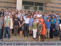 Large group of students posing for picture in front of school 